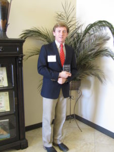 Hunter Robinson holding award plaque