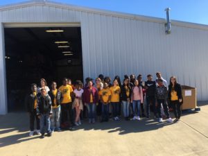 Group of Litchfield Middle School students in front of a large warehouse