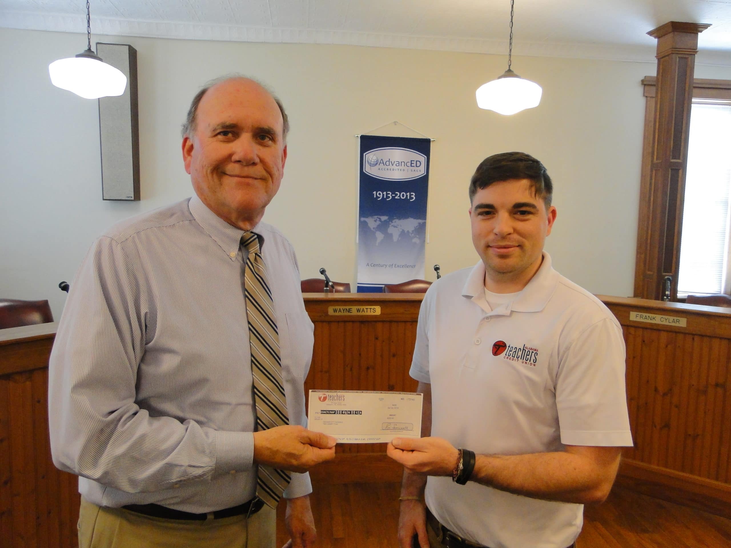 Superintendent receiving check from Joseph Wood, Alabama Teachers Credit Union