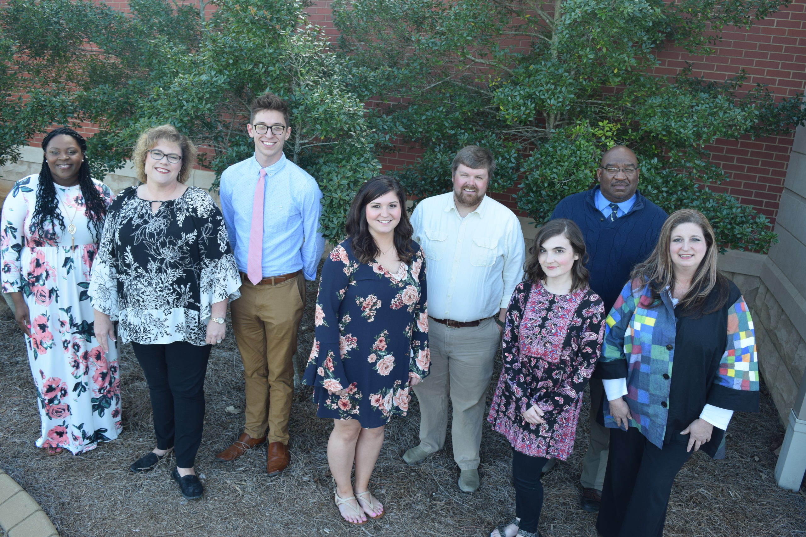 Teacher group of 8 standing in the bushes