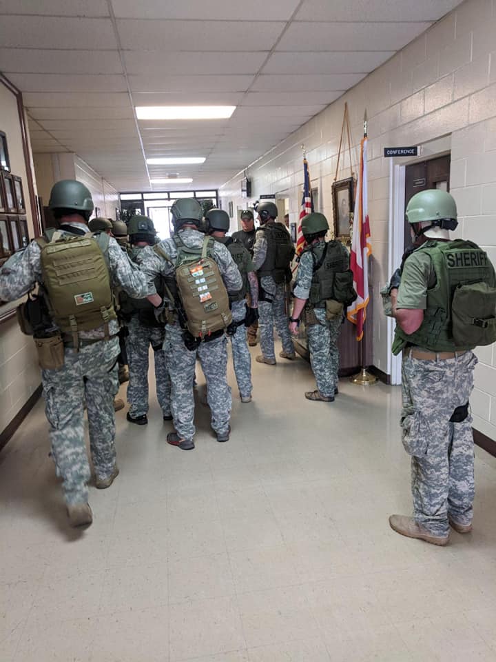 Group of camouflaged armed first responders in a hallway
