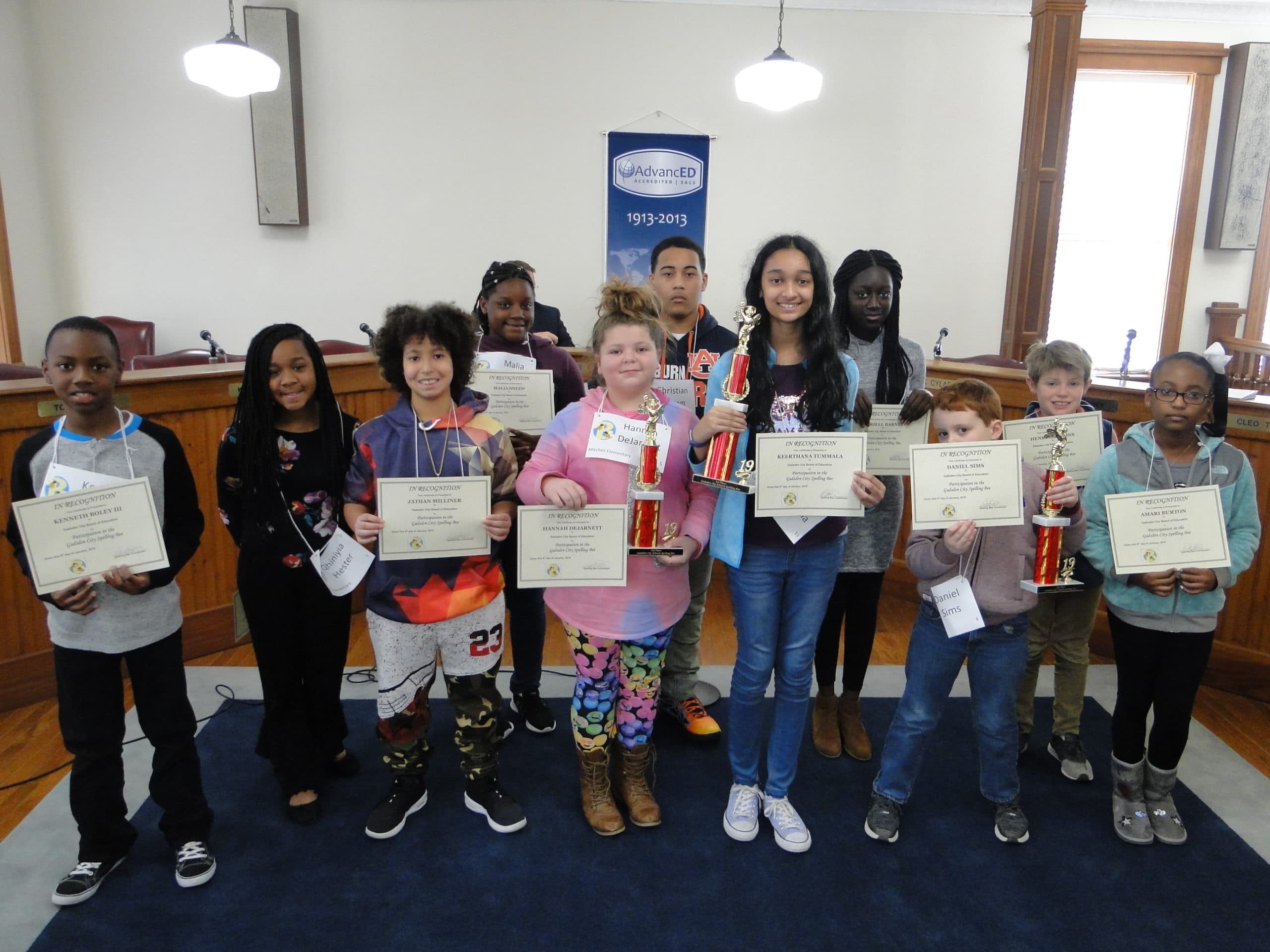 Students holding trophies and certificates