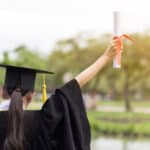Graduate holding diploma in the air