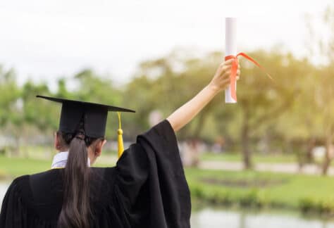 Graduate holding diploma in the air