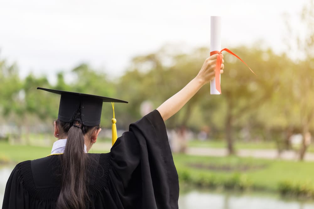 Graduate holding diploma in the air